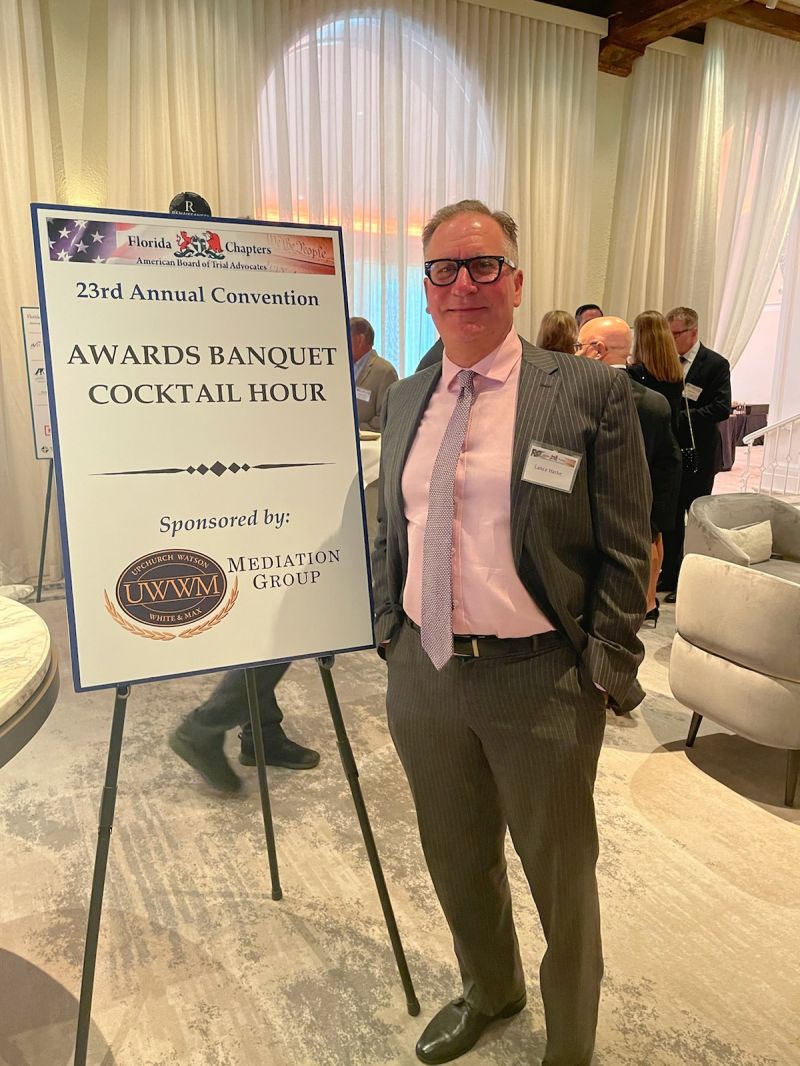 Lance Harke poses with the firm's sponsorship sign.