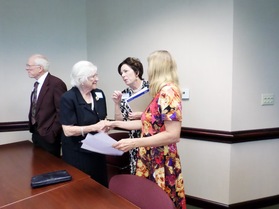 A seminar attendee shakes hands with Anna Jernigan.