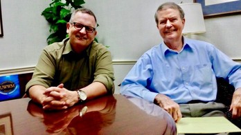 Author Gilbert King, left, visits with Dick Graham at the Daytona Beach office of Upchurch Watson White & Max in March 2017.